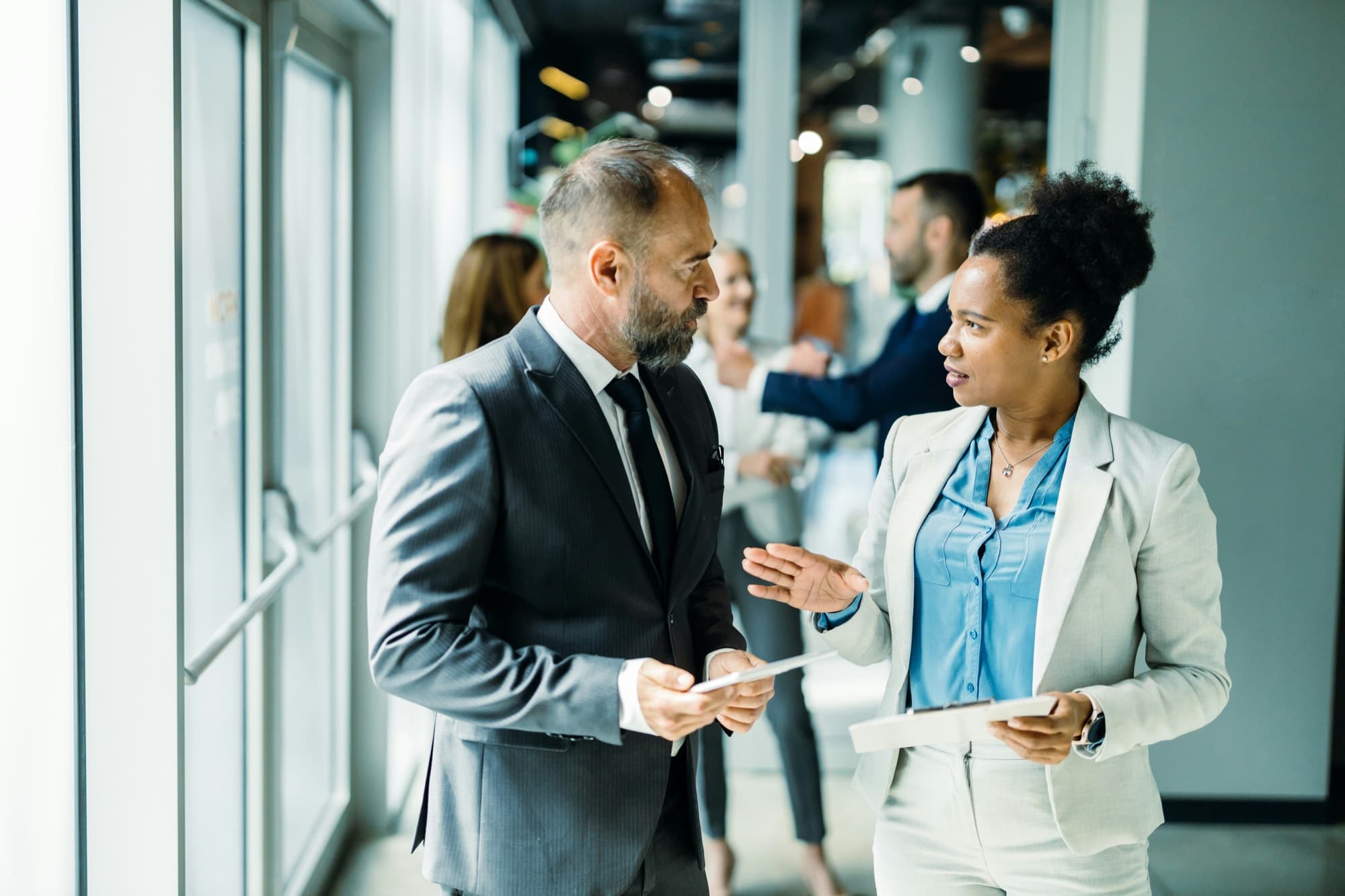 A senior advisor and a colleague in conversation in a modern office